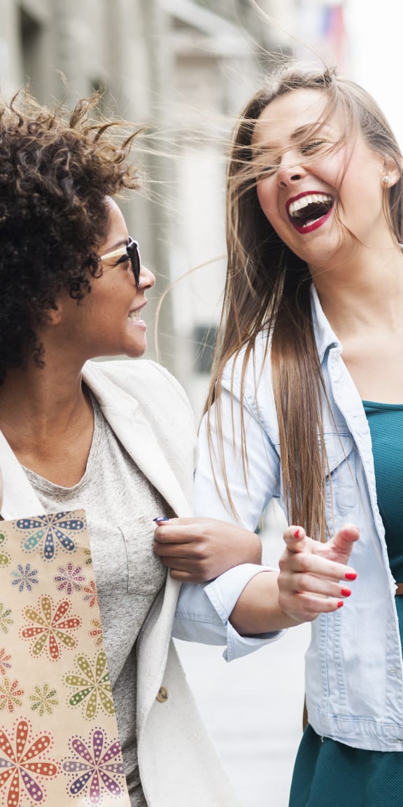 two women walking down the street with shopping bags
