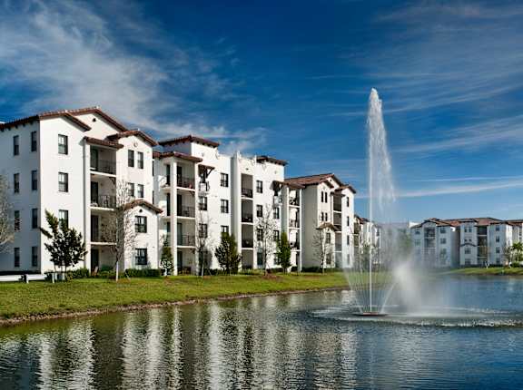 A fountain in front of apartment buildings.