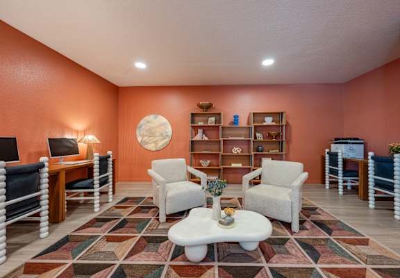 A living room with a white coffee table and a rug with a pattern of squares and rectangles.