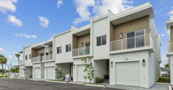 A row of modern townhouses with balconies and garages.