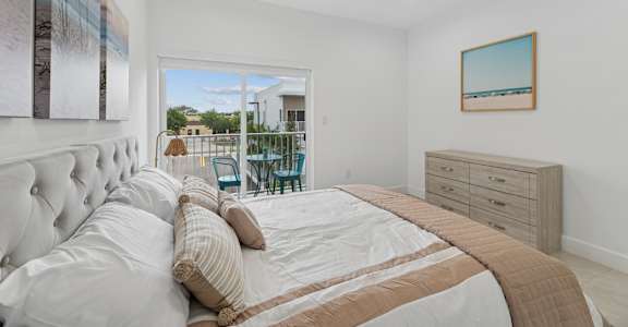 A bedroom with a large bed and a painting on the wall.