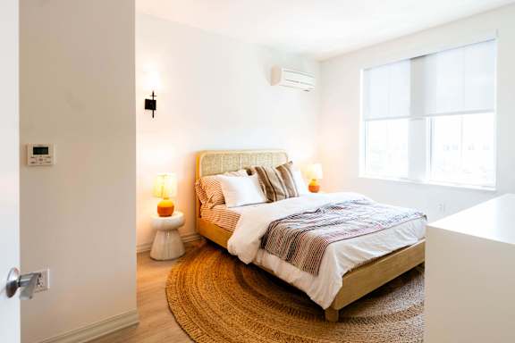 A bedroom with a bed, nightstand, and lamp.