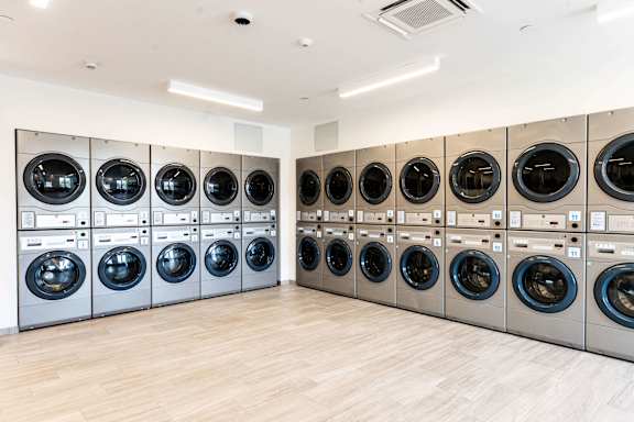 A row of washing machines are lined up in a room.