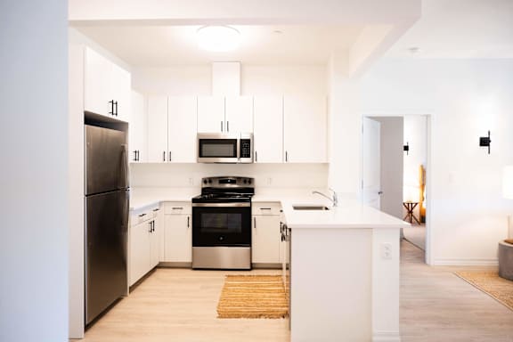 A modern kitchen with white cabinets and appliances.
