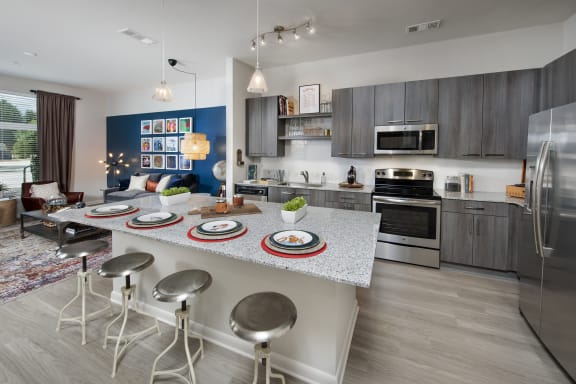 a kitchen with a large island with a breakfast bar and stainless steel appliances