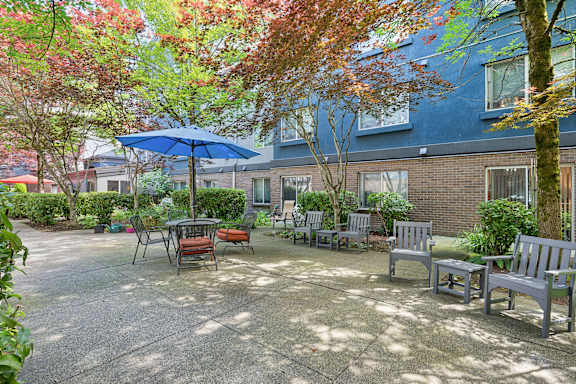 A patio with a table and chairs surrounded by trees.