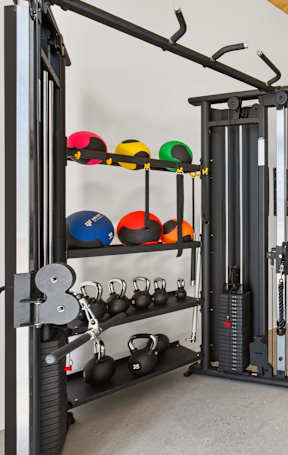 A gym with a variety of equipment including weights, a squat rack, and exercise bikes.
