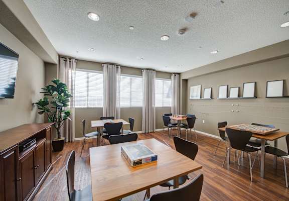 a common area with tables and chairs and a television at  Ventana Senior Apartments, Porter Ranch ,91326