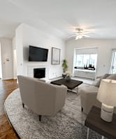A living room with a grey couch, a coffee table, a television, and a fireplace.