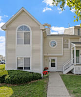 A house with a white door and windows with a small porch.