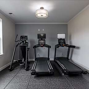 Three treadmills are lined up in a room.