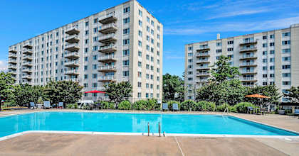 a swimming pool with an apartment building in the background