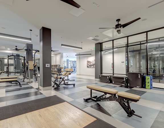 a gym with exercise equipment and mirrors in a building