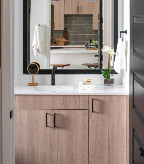 a bathroom with wooden cabinets and a large mirror