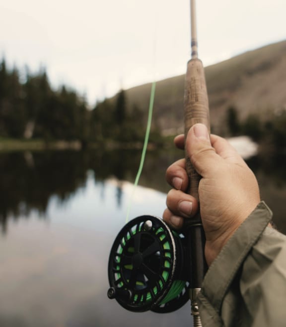 Man Holding Fishing Rod and Fishing at Lake
