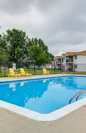 our apartments have a large swimming pool with yellow chairs