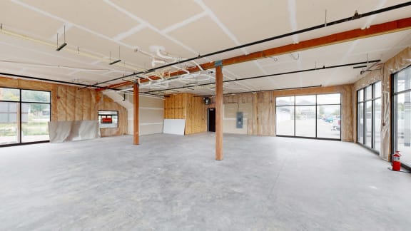 a large empty room with glass doors and a fire hydrant