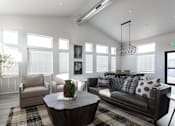 Thumbnail 1 of 8 - A living room with a black couch, a coffee table, and a potted plant.