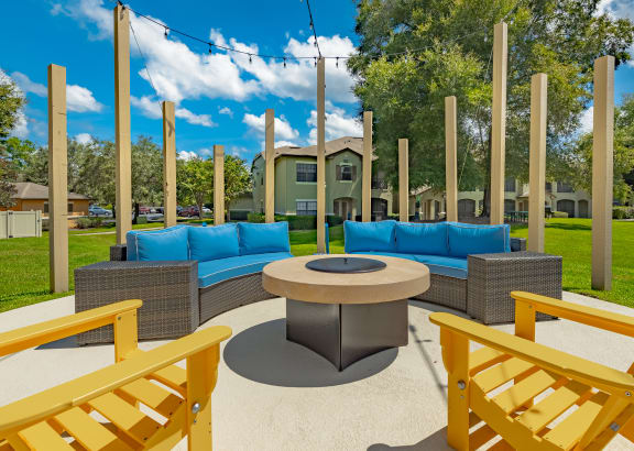 a patio with blue couches and a round table
