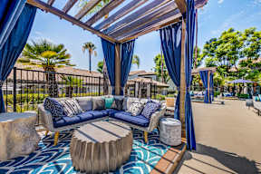 A patio with a blue couch and a canopy.