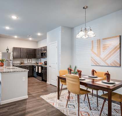 an open kitchen and dining room with a table and chairs and a kitchen and living