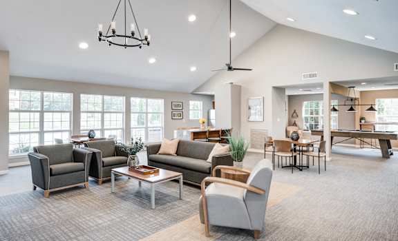 a living room with couches and chairs and a dining room with a table