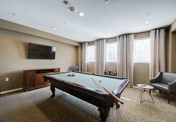 a game room with a pool table and a flat screen tv