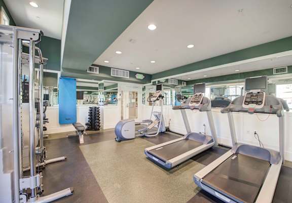 a room filled with cardio equipment and weights at  Ventana Senior Apartments, Porter Ranch ,91326