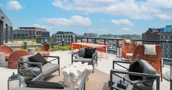 a roof top patio with furniture and a view of the city