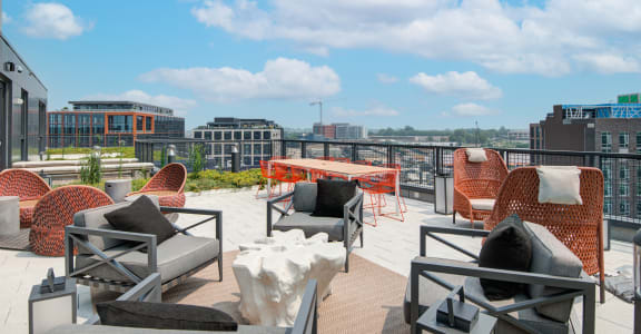 a roof top patio with furniture and a view of the city