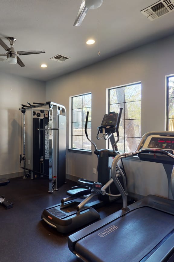 a gym with weights and cardio machines in it