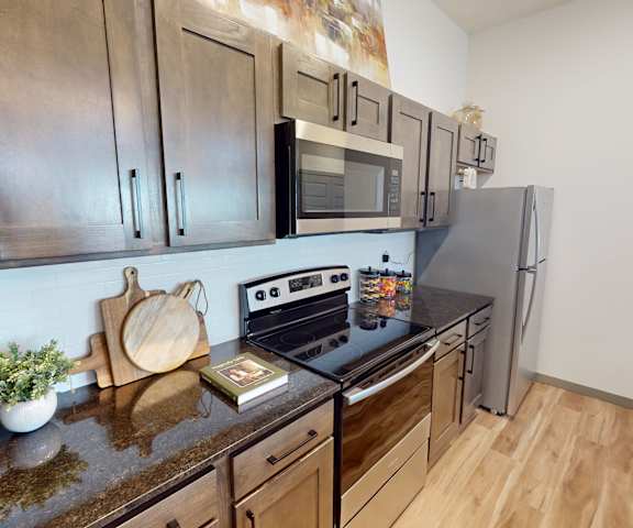 A kitchen with stainless steel appliances and wooden cabinets.