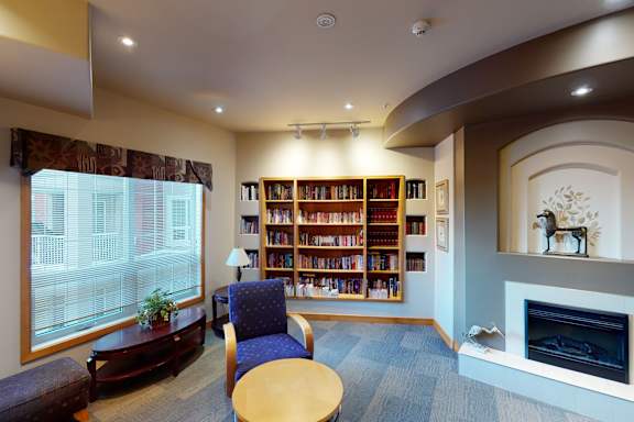 A living room with a fireplace and a bookshelf.