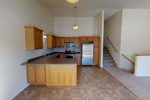 A kitchen with wooden cabinets and a tiled floor.