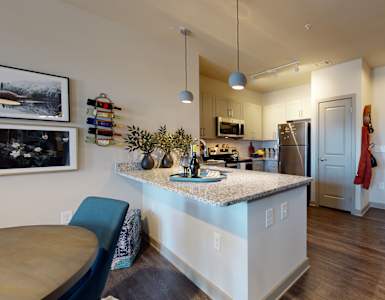 a kitchen with a large island and a stainless steel refrigerator at The Address Galleria, Matthews, NC, 28105