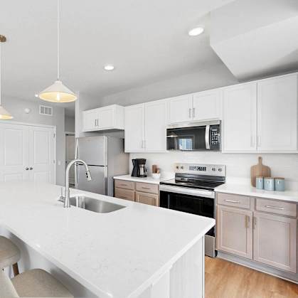 A modern kitchen with a white countertop and white cabinets.