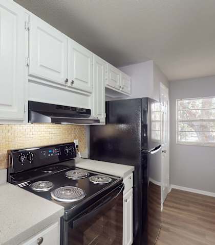 a kitchen with white cabinets and a black stove top oven