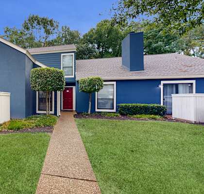 a blue house with a yard and a walkway at The Vale Apartments and Townhomes, Cordova
