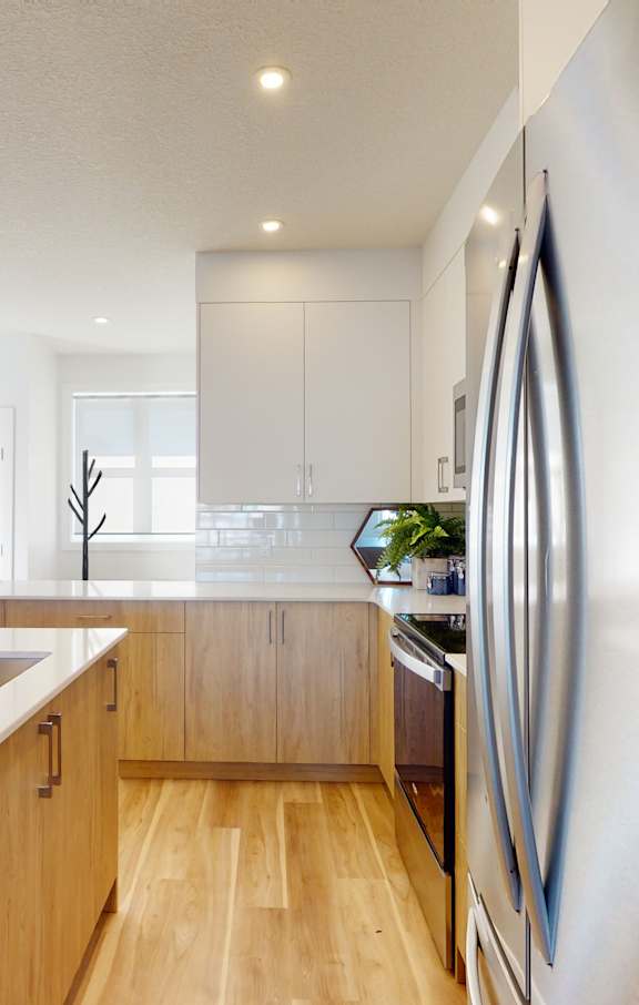 A modern kitchen with a stainless steel refrigerator and wooden cabinets.
