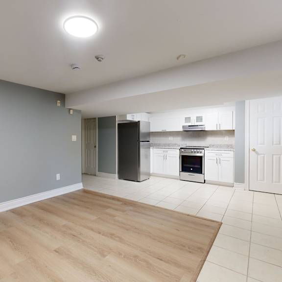 A kitchen with a table and chairs in the foreground and a refrigerator in the background.