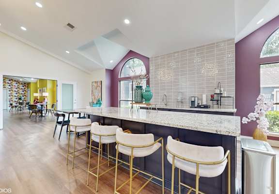 a kitchen with a long counter with bar stools at The Vale Apartments and Townhomes, Cordova