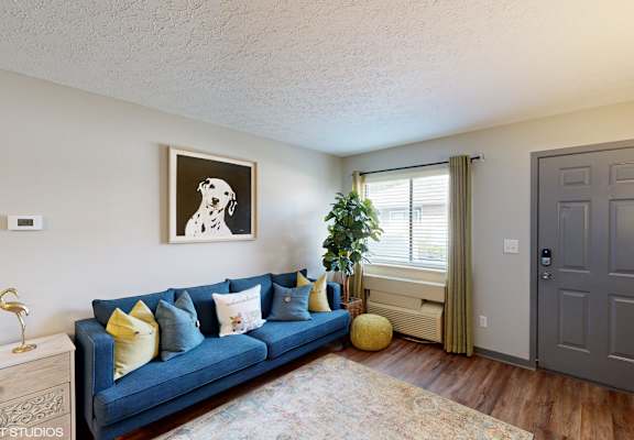 a living room with a blue couch and a grey door at Springburne at Polaris Apartments, Columbus, OH