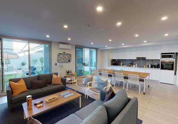 a living room with a couch and a table and a kitchen