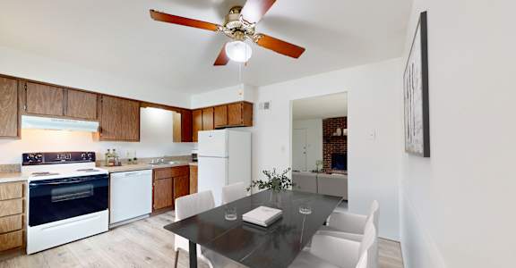 a kitchen and dining room with white appliances and a black dining table