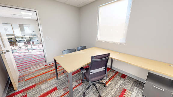 A conference room with a table and chairs.