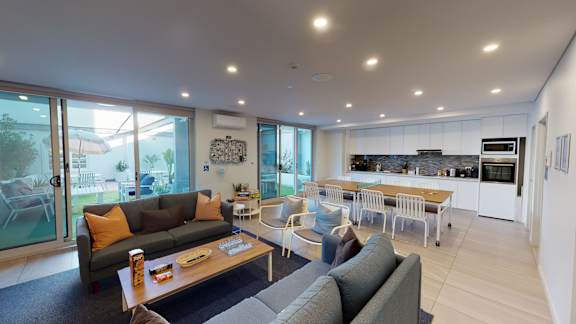 a living room with a couch and a table and a kitchen