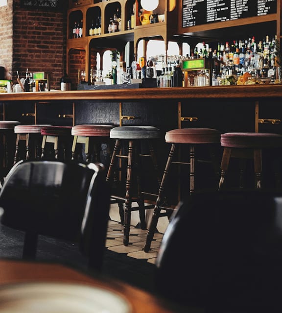 a view of a bar with stools at a bar