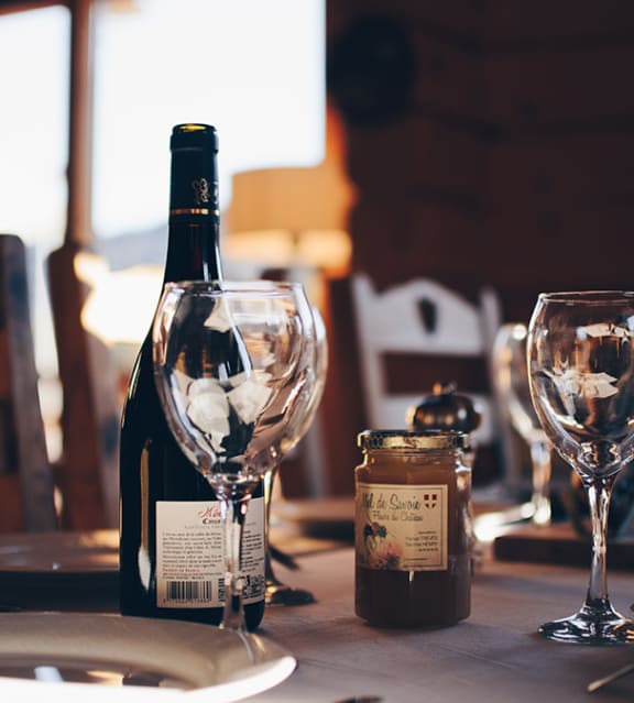 a bottle of wine sitting on a table with wine glasses
