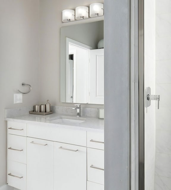 a white bathroom with a sink and a mirror