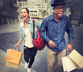 a man and a woman walking down the street holding shopping bags